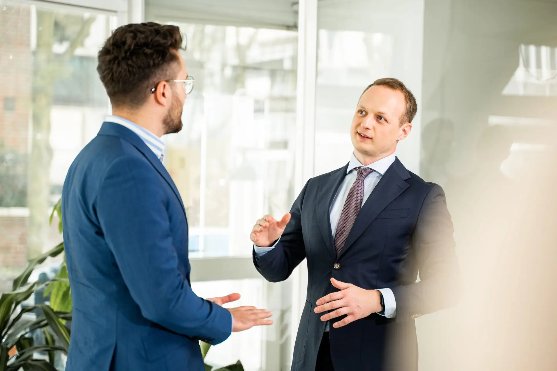 Zwei Geschäftsleute von Ainovate im Gespräch über KI-Strategien und digitale Transformation im Unternehmensumfeld